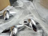 three chrome spoons sitting on top of a piece of plastic