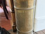 un grand vase contenant des parapluies, posé par terre