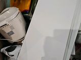 a white refrigerator in a cardboard box full of stuff
