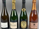 quatre bouteilles de vin sont alignées sur une table