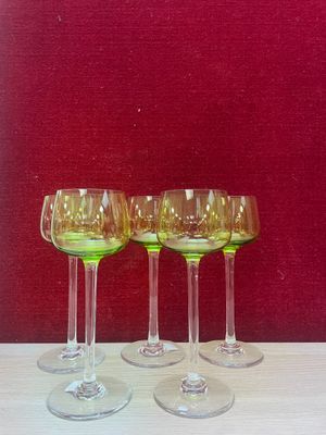 four wine glasses sitting on a table in front of a red wall