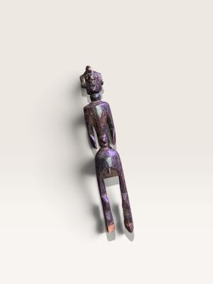 un gros plan sur une figurine représentant une personne assise sur une surface blanche