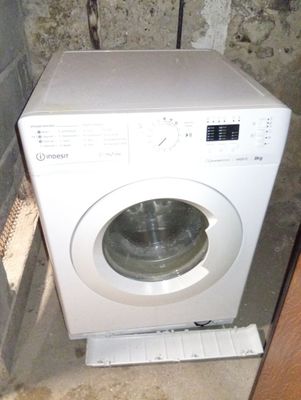 an image of a washing machine in the corner of a room