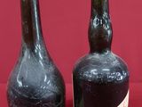two bottles of liquor sitting next to each other on a red surface