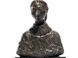 statue d'une femme assise sur un rocher, posée sur un socle noir