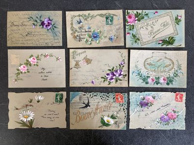 several old postcards with flowers and birds on them on a table