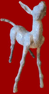 une petite statue représentant un cerf sur fond rouge