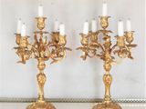 deux chandeliers en or posés sur une table en marbre