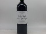 une bouteille de vin rouge posée sur une table blanche
