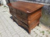 une commode en bois posée sur un trottoir en briques
