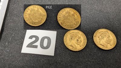 quatre souverains d'or et une règle posée sur une table