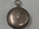 a small silver pocket watch on a white surface