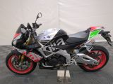 a silver and red motorcycle parked on a black and white checkered floor