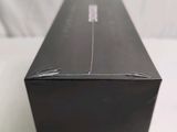 a black box with a green lid on a white surface