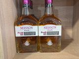 deux bouteilles d'alcool posées sur une étagère dans un magasin