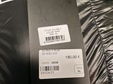 the label on the back of a black jacket is attached to the back of a black jacket