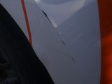 a close up of a white car with orange stripes on it