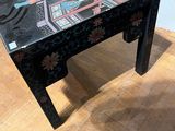 a black table with a design on it on a wooden floor