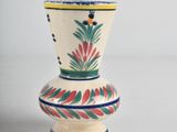 a white vase with a red and green design on it