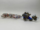 two glass fish sitting next to each other on a white surface