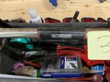 une valise contenant des outils, posée par terre