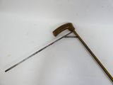 un petit marteau en métal muni d'un long manche, posé sur une surface blanche