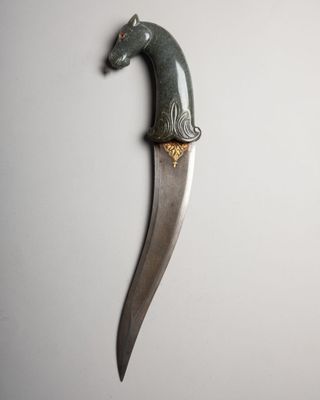 a close up of a knife with a horse head on it