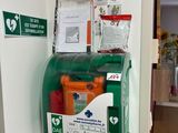 une boîte aux lettres verte et blanche fixée au mur à côté des toilettes