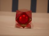 a small red object sitting on a white surface
