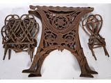 trois chaises anciennes en fonte et une table sur fond blanc
