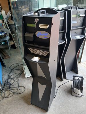 trois machines à sous électroniques noires et argentées dans une pièce