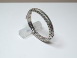 bague en argent ornée de pierres multicolores posées sur un fond blanc