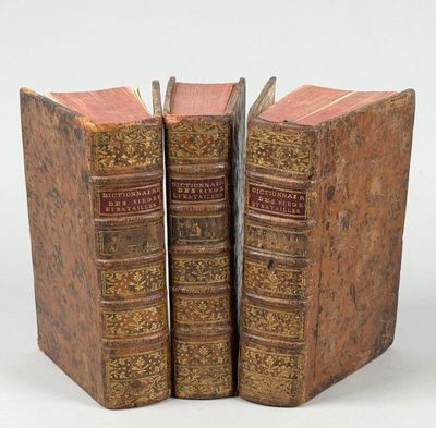 deux vieux livres posés l'un sur l'autre sur une surface blanche