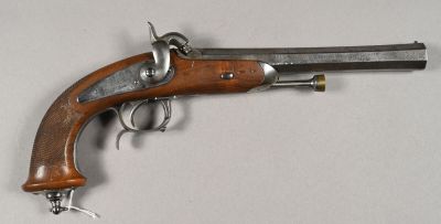 un vieux pistolet avec une poignée en bois sur une surface blanche