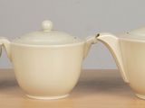 three cups and a saucer sitting on a table