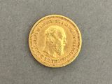a close up of a gold coin on a gray surface