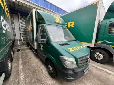 deux camions verts garés l'un à côté de l'autre sur un parking