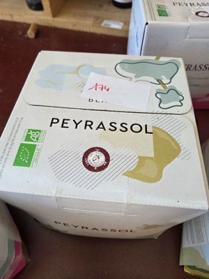 a box of peyrassol sitting on a table next to a cup of coffee