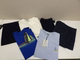 four men ' s t - shirts are sitting on a white table