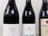 three bottles of wine are lined up on a table