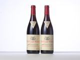 two bottles of red wine sitting on top of a table