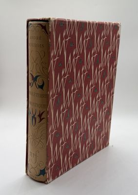 an old book sitting on top of a white table next to a white wall
