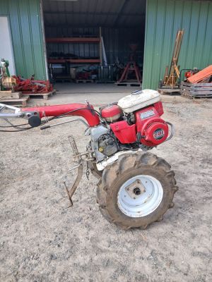 a red tractor that is parked in front of a building