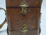 a small brown leather bag with brass hardware on it