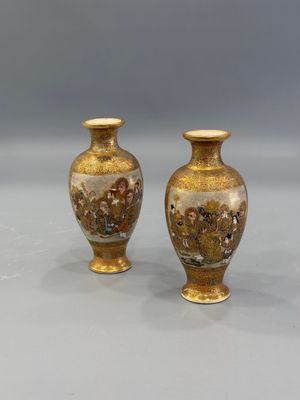 pair of vases on a table with a gray background