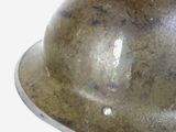 a close up of a metal helmet on a white background