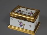 une boîte ancienne en porcelaine, ornée de dorures et de motifs floraux