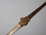 an image of a wrist watch with a gold band on a white surface