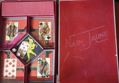 une boîte rouge contenant des cartes à jouer, posée sur une table