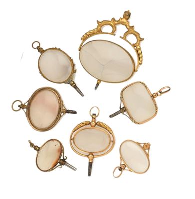 Plusieurs bijoux sont disposés en cercle sur une surface blanche